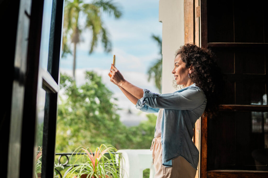 woman taking a picture in a hotel room - arise hotel marketing