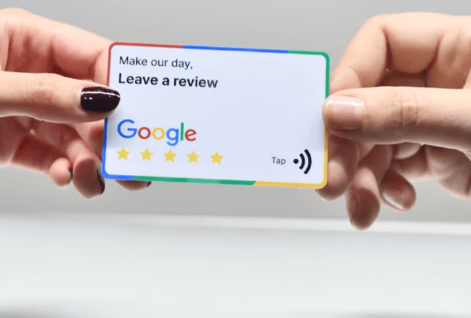 Person handing a customer a card that invites them to leave a Google review for their business
